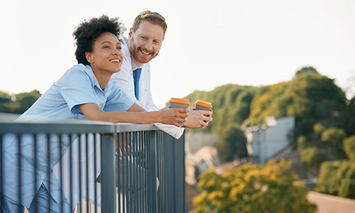 2 people leaning on a railing smiling