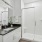 glassed, walk-in shower with ample lighting in bathroom